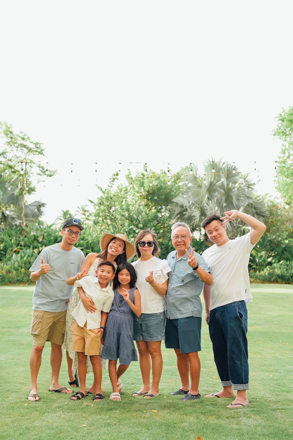 Family of six standing together on a grassy lawn.