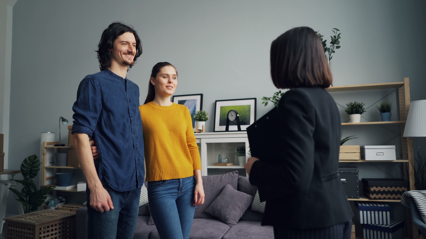 Real estate agent shows unfurnished home to couple.